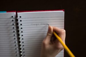 hand writing with pencil on lined notebook