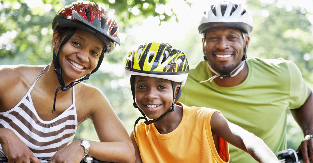 Image of family wearing bike helmets