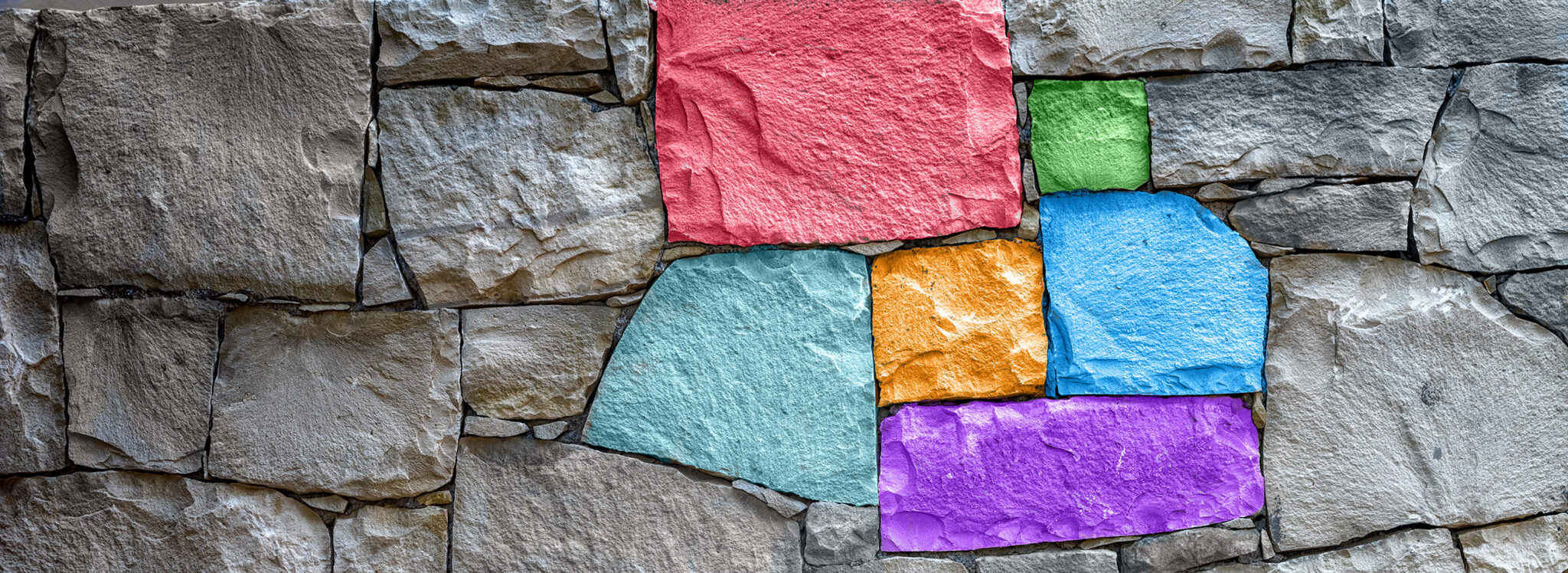 stone wall with six stones colorized in different colors.