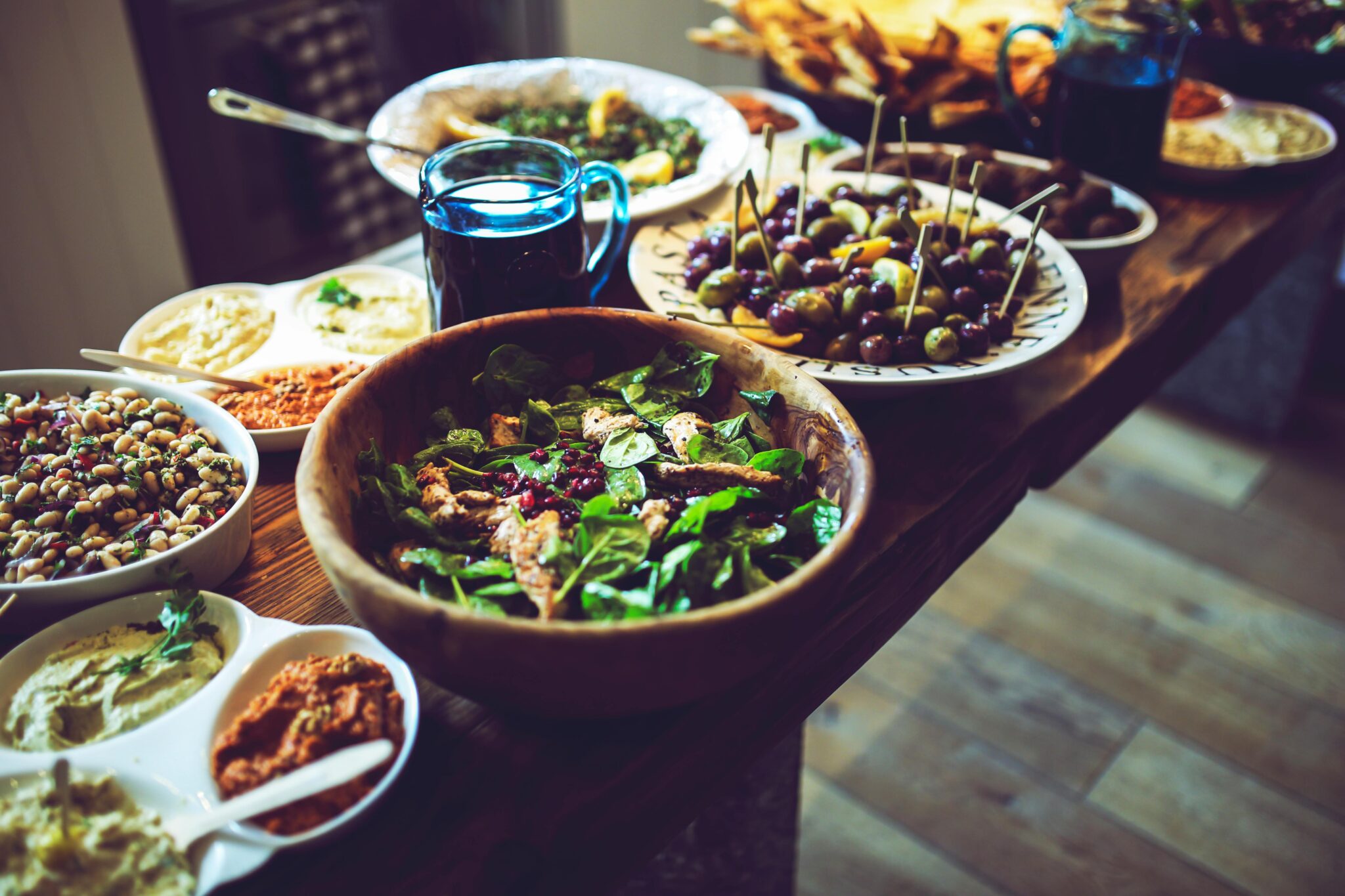 food spread with salad chickpeas, hummus, olives in bowls.